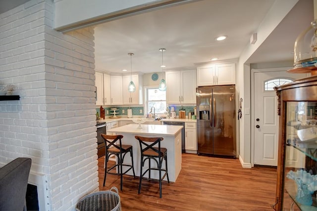 21 Potter Ln, Levittown, NY 11756 - kitchen with stainless steel refrigerator with ice dispenser, dishwashing machine, light countertops, wood finished floors, and backsplash