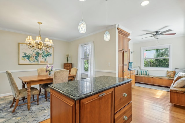 kitchen featuring light wood finished floors, a wealth of natural light, pendant lighting, and ornamental molding