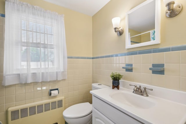 bathroom featuring radiator, tile walls, toilet, and vanity