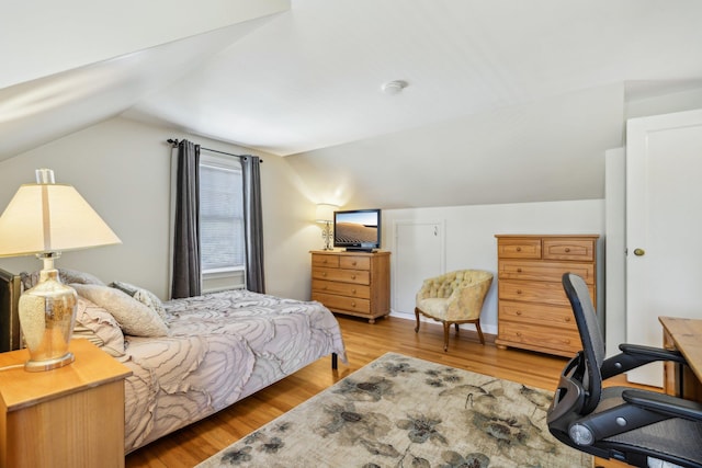 bedroom with lofted ceiling and light wood-style flooring