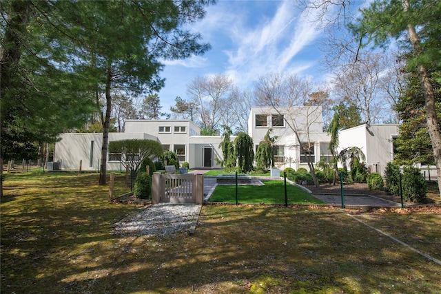 view of front facade featuring a gate, stucco siding, a front lawn, and a fenced front yard