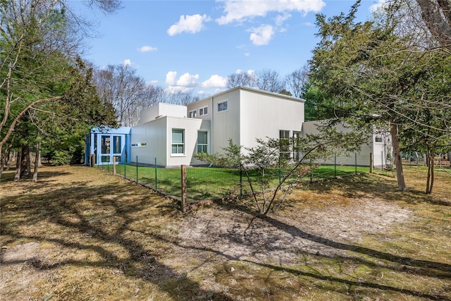 view of side of home with fence and a lawn