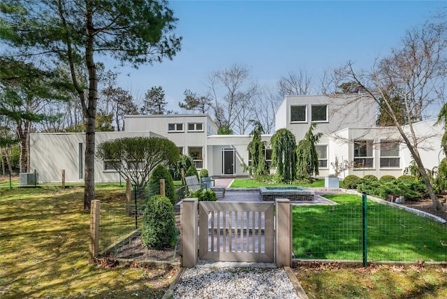 rear view of property with a yard, central air condition unit, a fenced front yard, and a gate