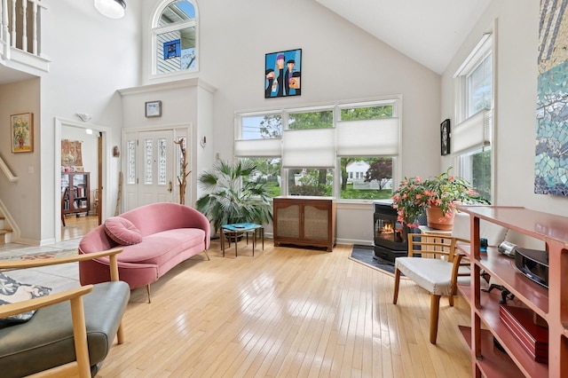 91 Soundview Dr, Rocky Point, NY 11778 - sitting room featuring high vaulted ceiling, a wood stove, wood-type flooring, stairs, and baseboards