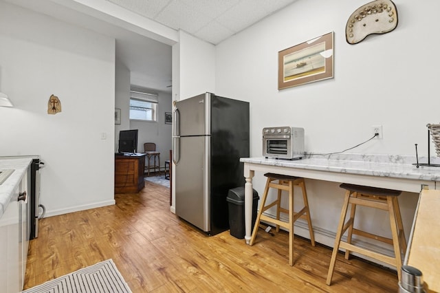 91 Soundview Dr, Rocky Point, NY 11778 - kitchen featuring freestanding refrigerator, a desk, light wood-style floors, a drop ceiling, and light stone counters