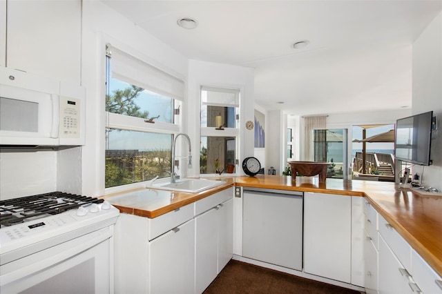 592 Ocean Walk, Fire Island Pines, NY 11782 - kitchen featuring white appliances, a sink, butcher block countertops, and white cabinetry