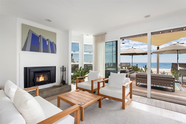 592 Ocean Walk, Fire Island Pines, NY 11782 - living room featuring a glass covered fireplace, a water view, and wood finished floors
