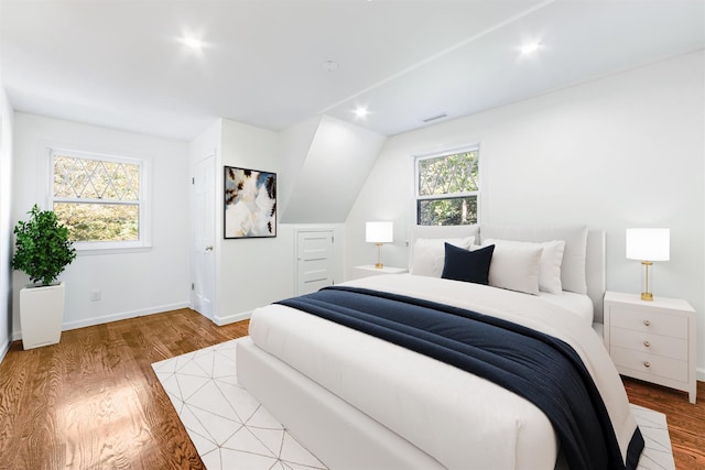 bedroom with visible vents, wood finished floors, baseboards, and recessed lighting