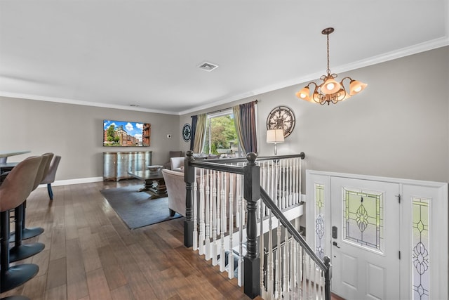 interior space featuring wood finished floors, visible vents, a chandelier, crown molding, and baseboards