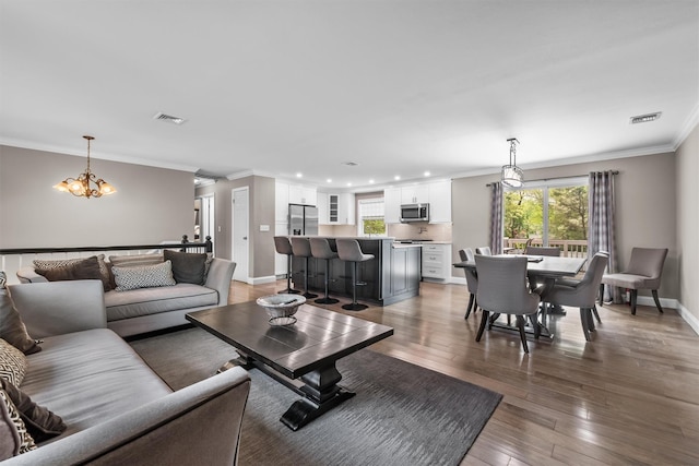 living area featuring an inviting chandelier, plenty of natural light, and visible vents