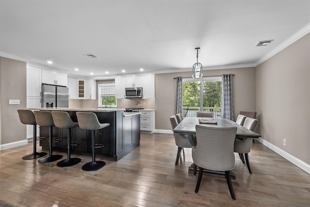 dining space with plenty of natural light, visible vents, and ornamental molding