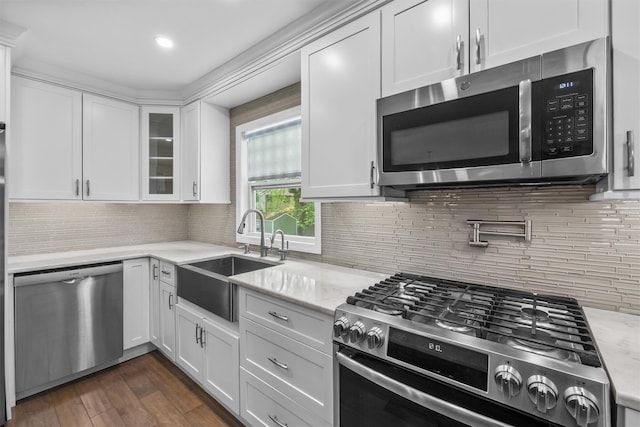 kitchen featuring a sink, stainless steel appliances, dark wood-type flooring, white cabinetry, and glass insert cabinets