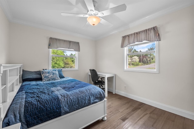 bedroom with baseboards, ornamental molding, ceiling fan, and wood finished floors