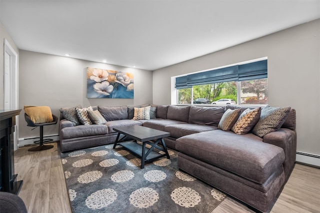 living room featuring wood finished floors, baseboard heating, and recessed lighting