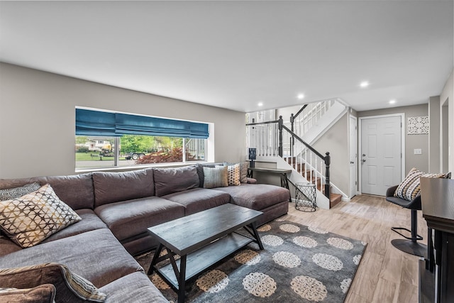 living room featuring light wood-type flooring, stairway, and recessed lighting