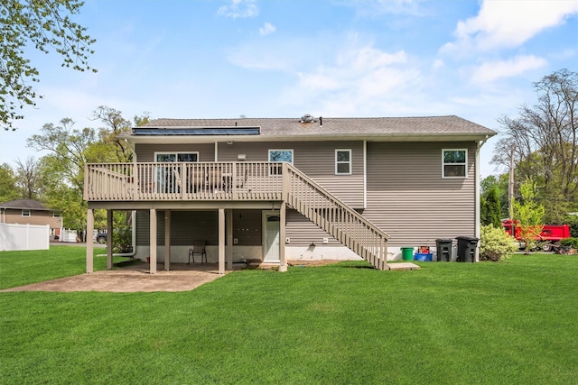 rear view of property with stairway, a wooden deck, a patio, and a yard