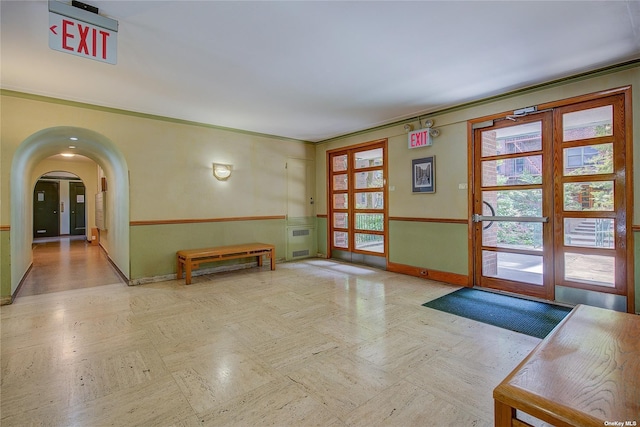 entryway with baseboards, arched walkways, and french doors