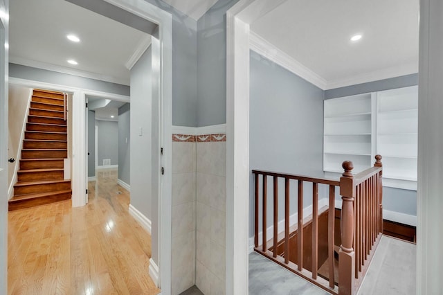corridor with crown molding, an upstairs landing, wood finished floors, and recessed lighting