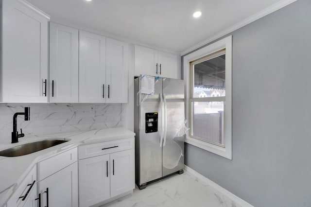 kitchen featuring a sink, white cabinetry, stainless steel fridge, and marble finish floor