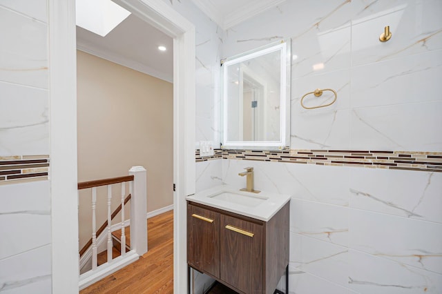 bathroom featuring wood finished floors, vanity, ornamental molding, and recessed lighting