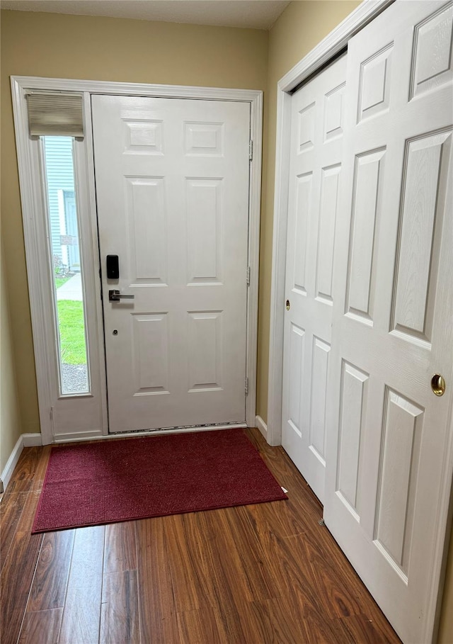 entryway with baseboards and dark wood-type flooring