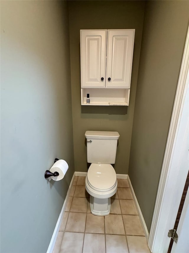 bathroom with tile patterned flooring, toilet, and baseboards
