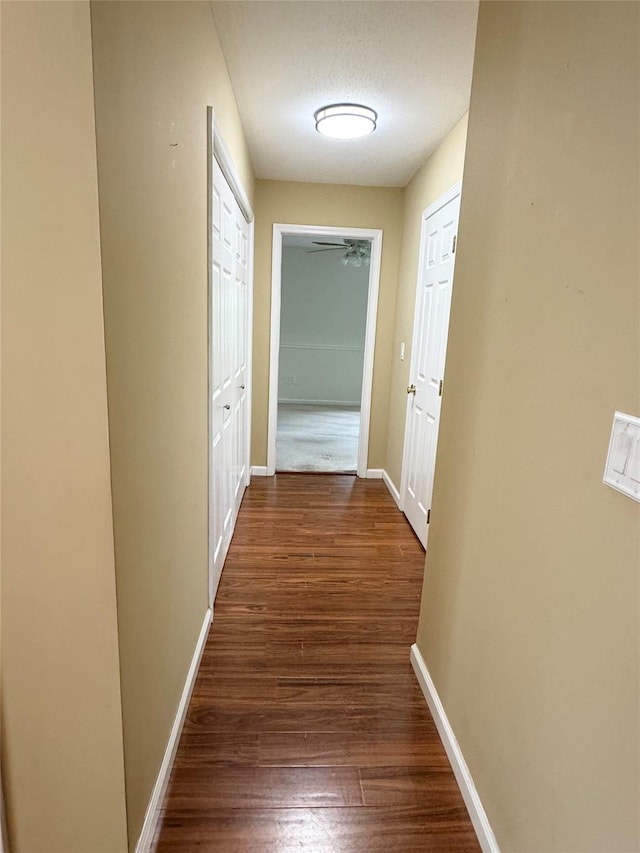 hall featuring wood finished floors and baseboards