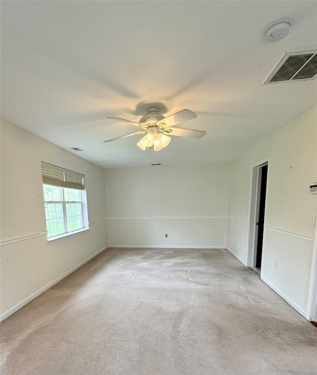 unfurnished room with light colored carpet, ceiling fan, baseboards, and a smoke detector