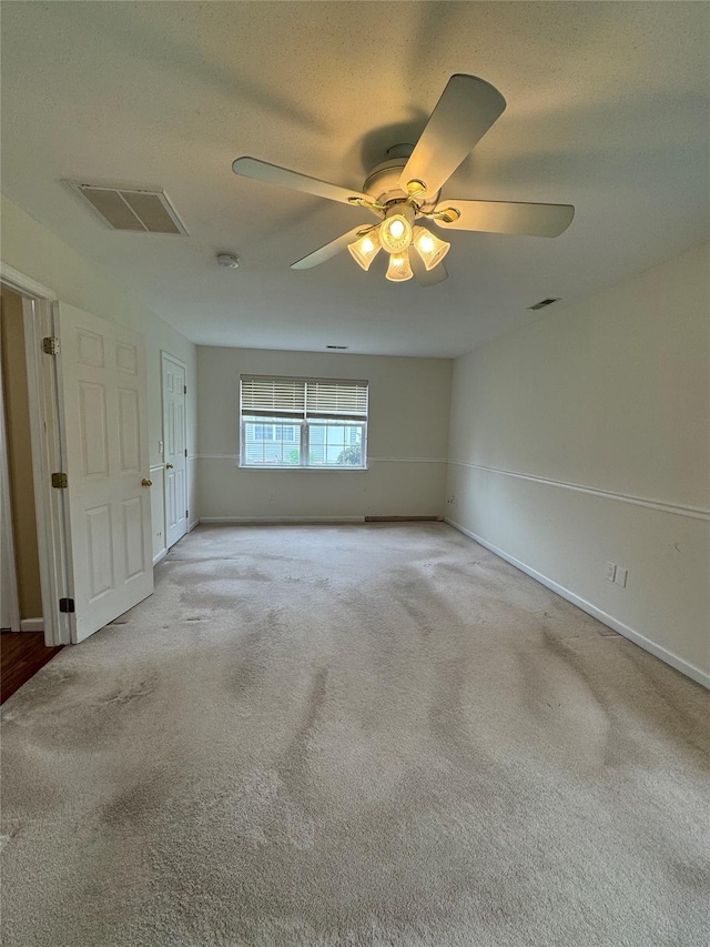 empty room featuring ceiling fan, carpet flooring, and baseboards