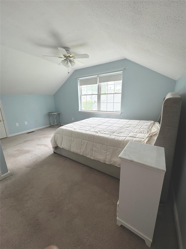carpeted bedroom featuring lofted ceiling, a ceiling fan, baseboards, and a textured ceiling