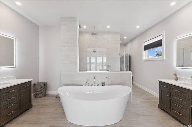 894 S Long Beach Ave, Freeport, NY 11520 - full bathroom featuring a stall shower, two vanities, a freestanding bath, recessed lighting, and wood finished floors