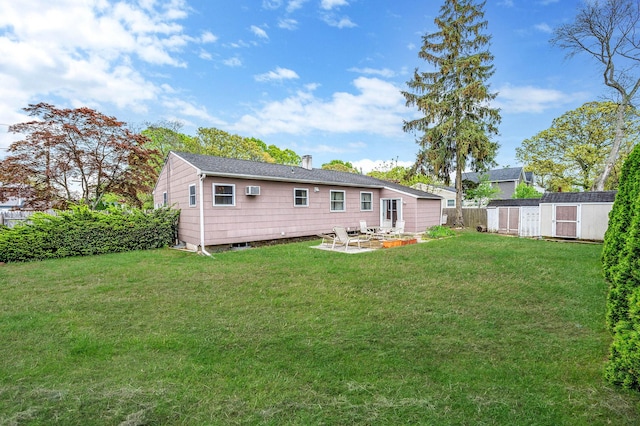 rear view of property with a storage shed, a patio area, and an outdoor structure
