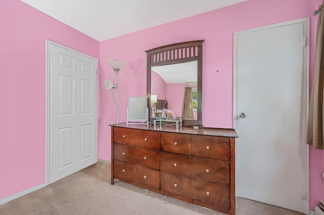 bedroom featuring light colored carpet and baseboard heating