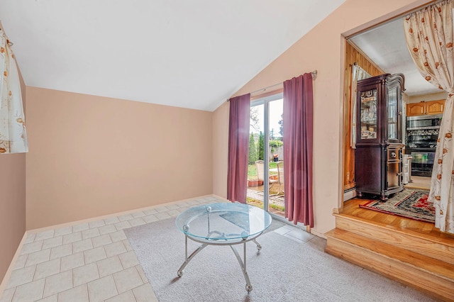 sitting room with tile patterned floors, vaulted ceiling, and a baseboard heating unit