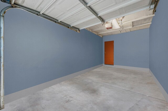 garage featuring a garage door opener and baseboards