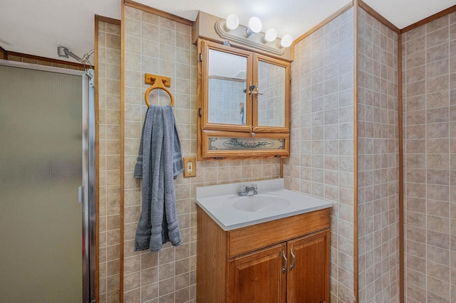 full bath with a stall shower, tile walls, and vanity
