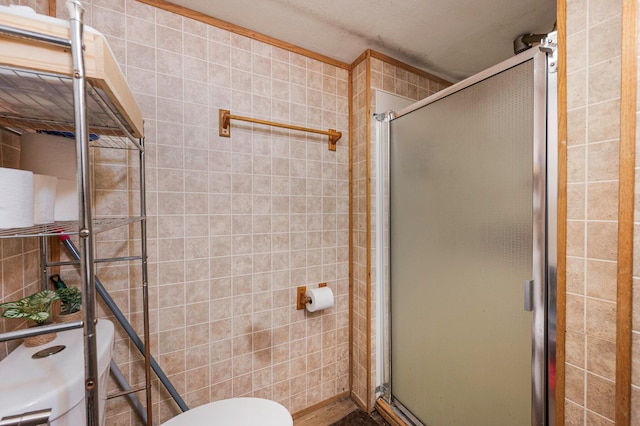 bathroom with a shower stall and toilet
