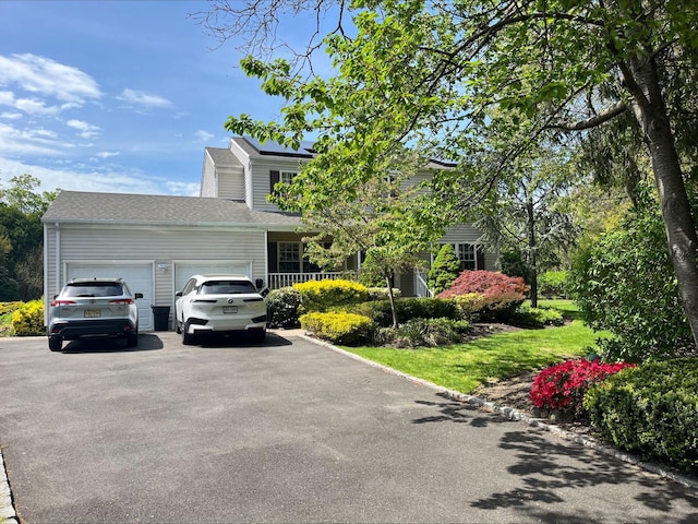 obstructed view of property with driveway and a garage