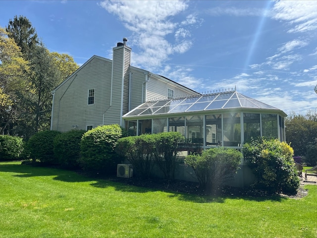 rear view of house featuring a lawn and a chimney