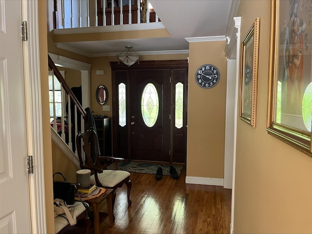 entryway with ornamental molding, a wealth of natural light, stairway, and wood finished floors