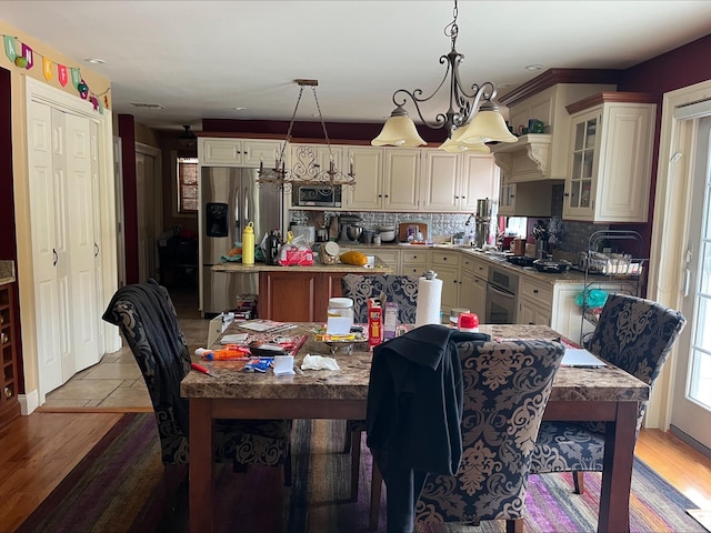 kitchen featuring an inviting chandelier, appliances with stainless steel finishes, tasteful backsplash, and a kitchen island