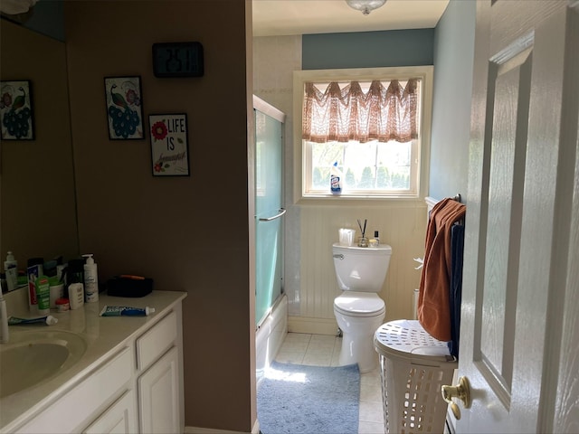 bathroom featuring tile patterned floors, baseboards, vanity, toilet, and enclosed tub / shower combo