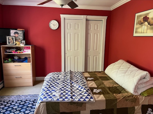 bedroom featuring carpet flooring, ceiling fan, ornamental molding, and a closet