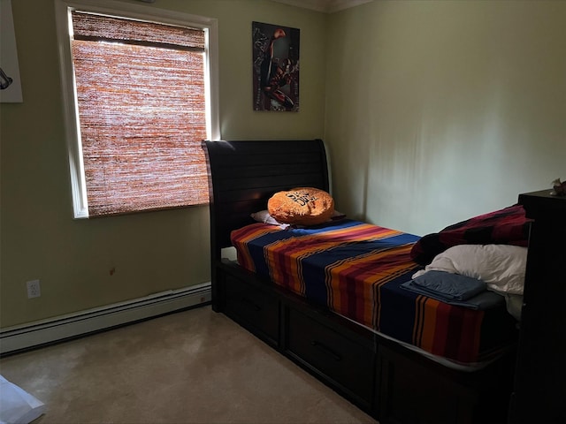 bedroom featuring multiple windows, a baseboard heating unit, and light colored carpet