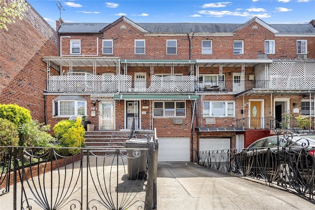 townhome / multi-family property featuring brick siding, driveway, fence, and a garage