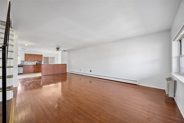 unfurnished living room with a baseboard radiator, a ceiling fan, baseboards, dark wood-type flooring, and a wall mounted AC