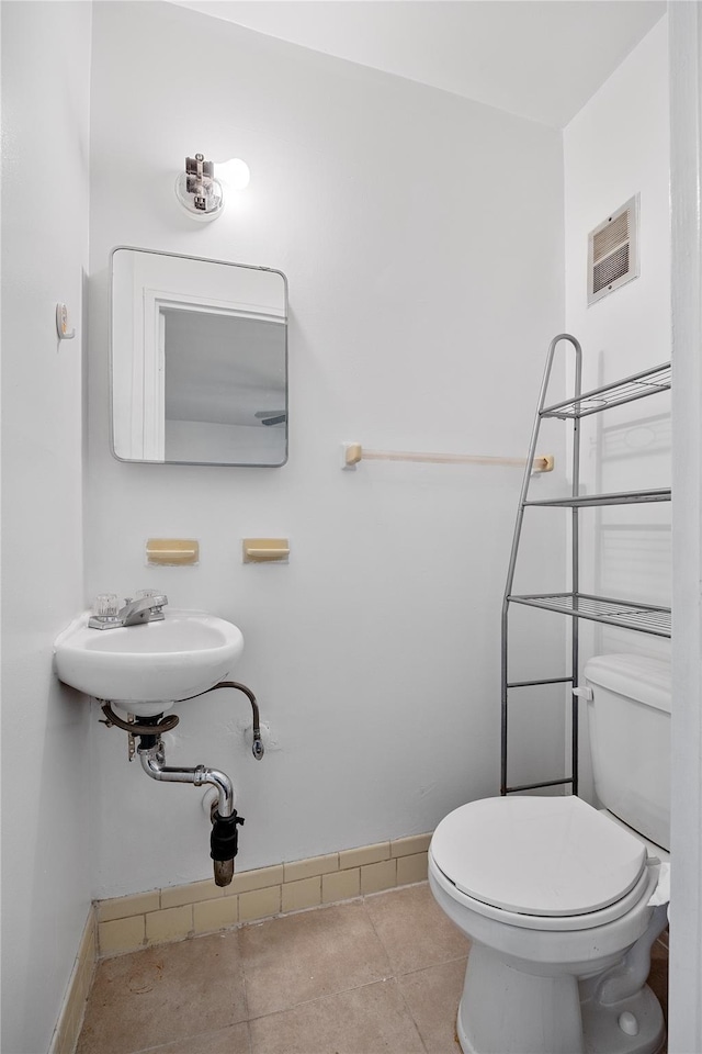 bathroom with tile patterned flooring, a sink, baseboards, and toilet