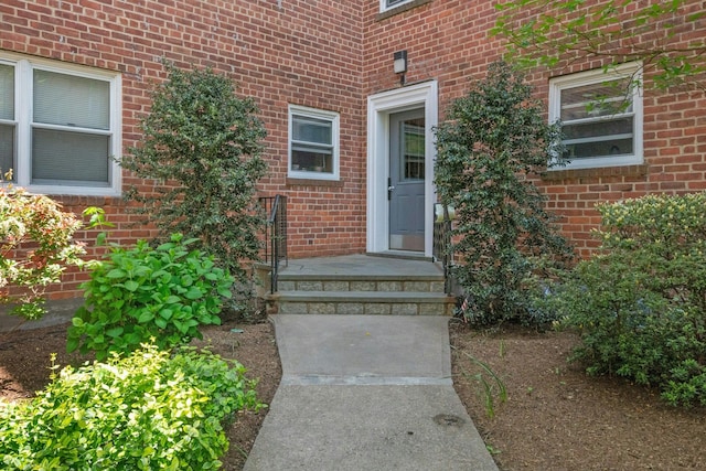 view of exterior entry featuring brick siding