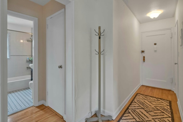 hallway featuring baseboards and light wood-type flooring