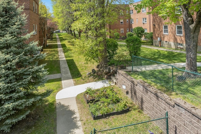 view of property's community with a yard and fence